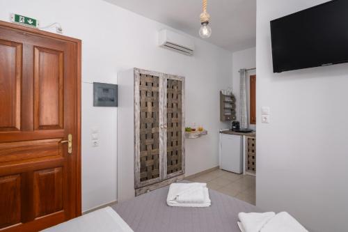 Una habitación con una cama y un televisor en la pared. en Sunset studio in Plaka, en Plaka Milou