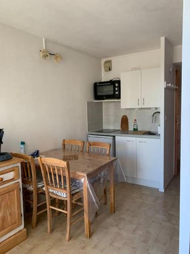 une cuisine avec une table et des chaises et une cuisine avec un comptoir dans l'établissement Logement avec vue sur mer, à Canet