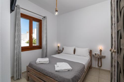 Un dormitorio con una cama con dos toallas encima. en Sunset studio in Plaka, en Plaka Milou