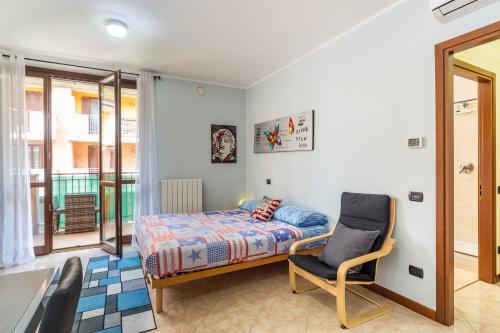 um quarto com uma cama, uma cadeira e uma janela em El Sol Residence - Modern house near Milan em Dresano