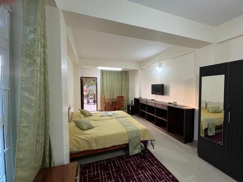 um quarto com uma cama grande e um espelho em Iamonlang Resort em Borpāni