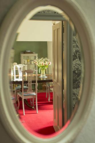 a dining room with a table with a vase of flowers at Percy Terrace Bed and Breakfast in Alnwick