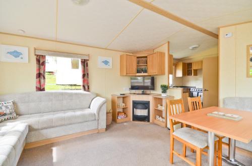 a caravan living room with a couch and a table at Greenwood in Cowes