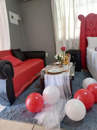 una sala de estar con una mesa con globos rojos y blancos en WAMPEX GUEST HOUSE POTCHESTROOM, en Potchefstroom