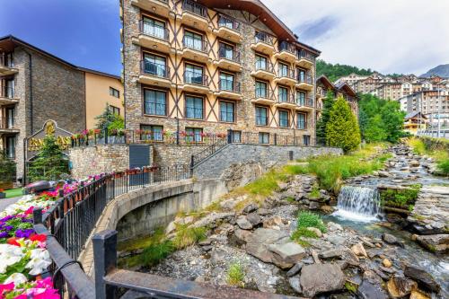 a building with a waterfall in front of a building at Hotel Princesa Parc in Arinsal
