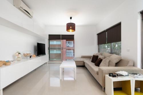 a living room with a couch and a table at 2 BDR Apartment W/Pool and Jacuzzi by LovelyStay in Portimão