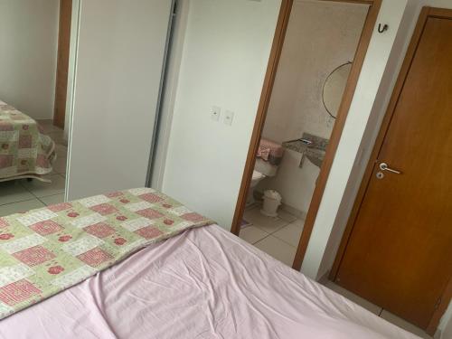 a bedroom with a bed and a door with a mirror at Quarto em condomínio no bairro Fátima in Fortaleza