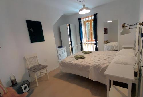 a bedroom with a bed and a desk and a window at Eli i Val in Rovinj