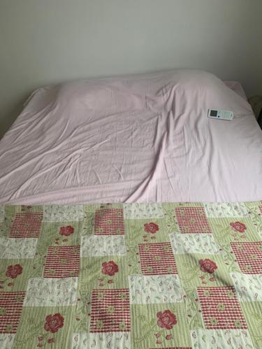 a bed with a quilt on top of it at Quarto em condomínio no bairro Fátima in Fortaleza