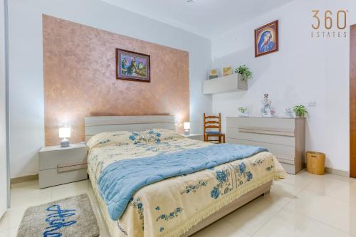 - une chambre avec un lit et une couette bleue dans l'établissement Charming 2BR home in the heart of Marsaxlokk by 360 Estates, à Marsaxlokk