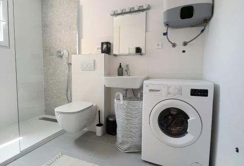 a white bathroom with a washing machine and a toilet at Eli i Val in Rovinj