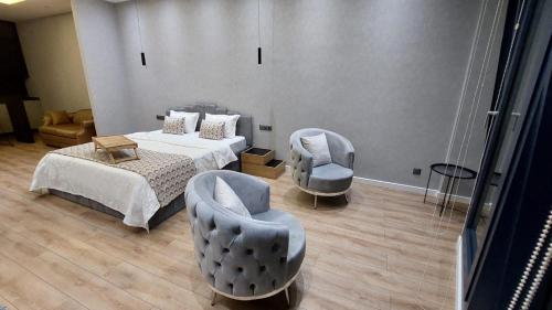 a bedroom with two beds and two chairs at King David Residance in Tbilisi City