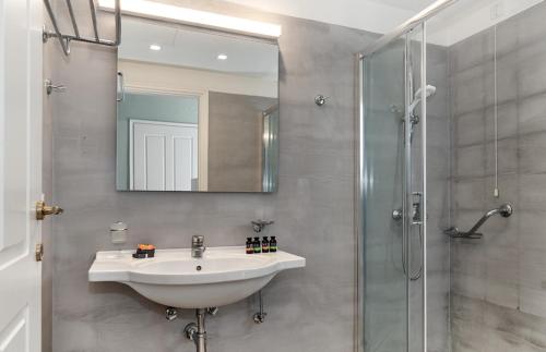 a bathroom with a sink and a shower at Bella Mare Hotel in Kassiopi