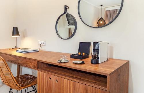 a wooden desk with a microwave and a mirror at Bella Mare Hotel in Kassiopi