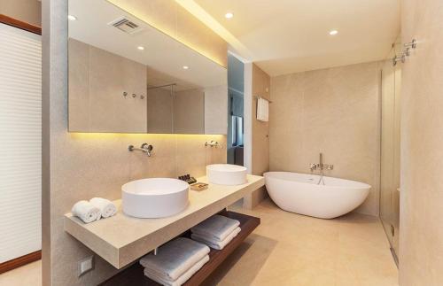 a bathroom with two sinks and a bath tub at Bella Mare Hotel in Kassiopi