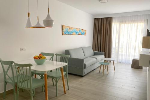 a living room with a couch and a table and chairs at Apartamentos Cordial Magec Taurito in Taurito