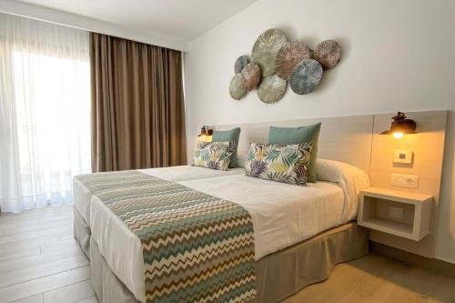 um quarto com uma cama grande e 2 almofadas em Apartamentos Cordial Magec Taurito em Taurito