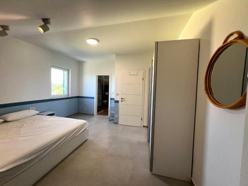 um quarto com uma cama e um espelho na parede em Penthouse SKY DELUXE em Novalja