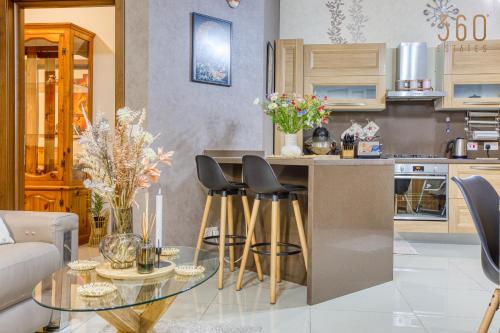 - une cuisine avec une table en verre et des chaises dans l'établissement Charming 2BR home in the heart of Marsaxlokk by 360 Estates, à Marsaxlokk