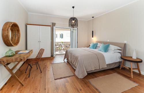 a bedroom with a bed and a desk and a table at Bella Mare Hotel in Kassiopi