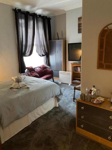 a bedroom with a bed and a window and a dresser at The Barley House in Plymouth