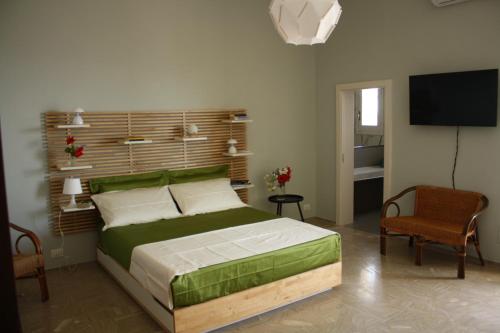 um quarto com uma cama e uma televisão de ecrã plano em Casa Bianca 4 camere 4 bagni in villa con giardino e terrazza em Santa Cesarea Terme