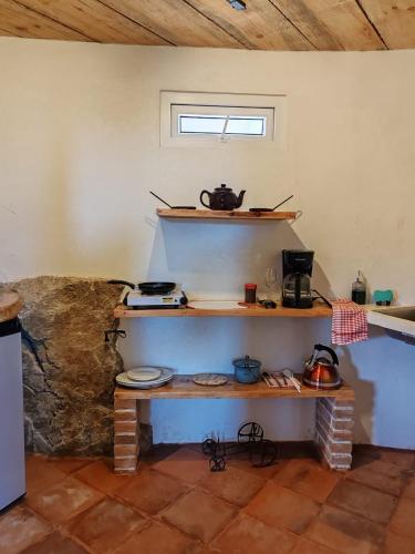 a room with a table and shelves in a kitchen at Finca Chuchiyá cabañas Tecpan in Tecpán Guatemala