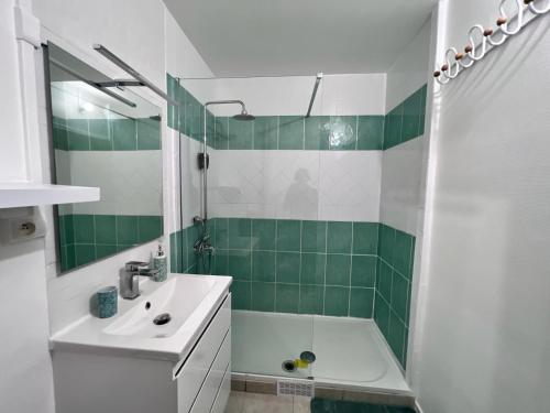 a bathroom with a tub and a sink and a mirror at Appartement au Duleing House in Orléans