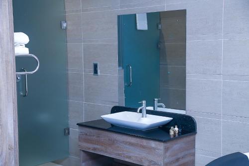 a bathroom with a sink and a mirror at Summerset Continental Hotel Maitama in Abuja