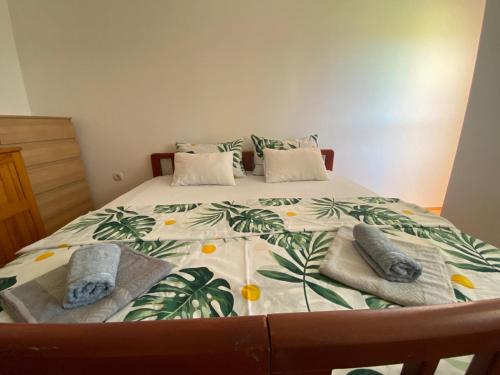 a bed with two pillows and towels on it at Apartments TEA in Trebinje