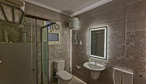 a bathroom with a toilet and a sink at Grand Plaza 6 Octobar in Qaryat ash Shamālī