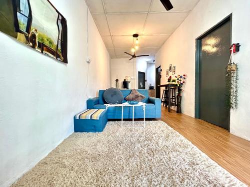 Sofá azul en la sala de estar con alfombra en Cozy 18 Entire 3 Bedroom @Alma Bukit Mertajam, en Bukit Mertajam