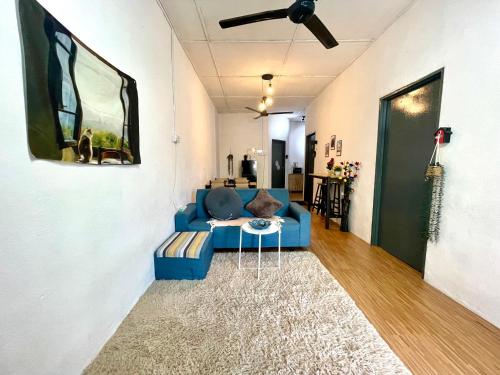 - un salon avec un canapé bleu et un ventilateur de plafond dans l'établissement Cozy 18 Entire 3 Bedroom @Alma Bukit Mertajam, à Bukit Mertajam