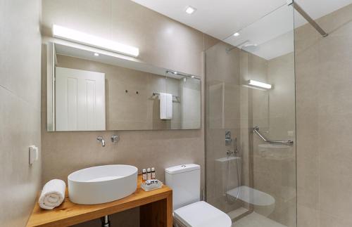 a bathroom with a toilet and a sink and a shower at Bella Mare Hotel in Kassiopi