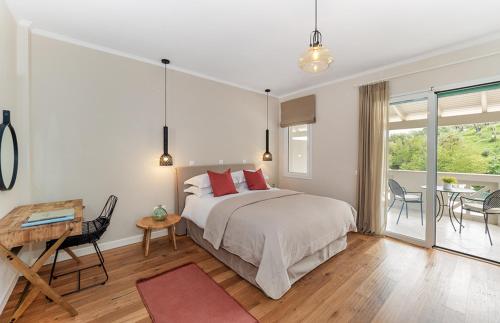 a bedroom with a bed and a table and chairs at Bella Mare Hotel in Kassiopi