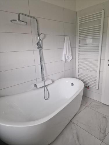 a white bath tub in a white tiled bathroom at Villa Ema in Zagreb