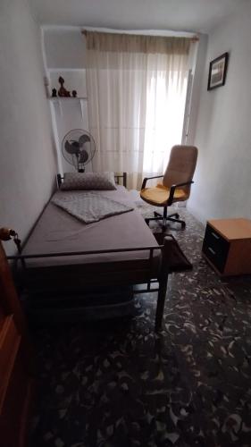 1 dormitorio con 1 cama, 1 silla y 1 ventana en Verano, en Alicante