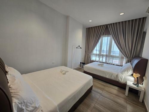 a hotel room with two beds and a window at The Octagon Ipoh City Centre Leisure Suite in Ipoh