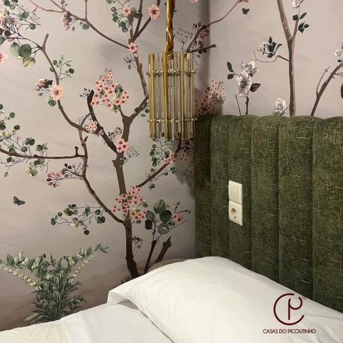a bedroom with a tree mural on the wall at Casas do Picoutinho in Ponte de Lima