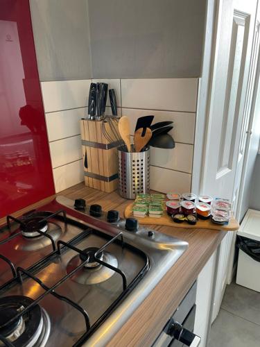 a kitchen counter with a stove and a sink at Top Floor 1 Bedroom Apartment with views over London in London