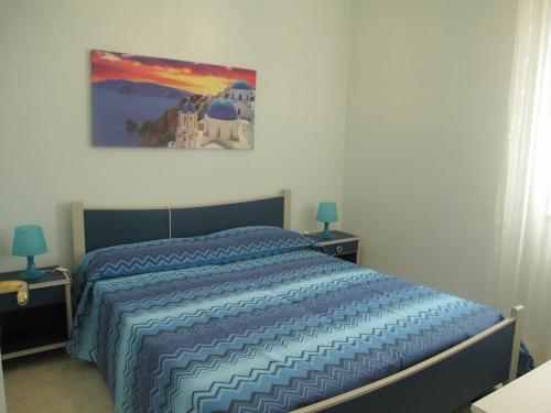 een slaapkamer met een bed met een blauw dekbed bij Appartamento Miramar in Grado-Pineta