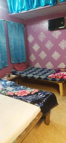a room with two beds and a wall at Shri Ganga kashi homestay in Varanasi