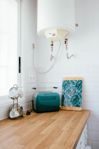 a room with a table with a blue suitcase on the floor at Loft del Sol in Peniscola