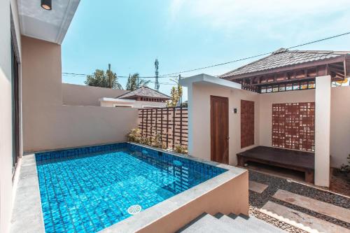 a swimming pool in the backyard of a house at Nemuru Villa Ubud Anyer in Anyer