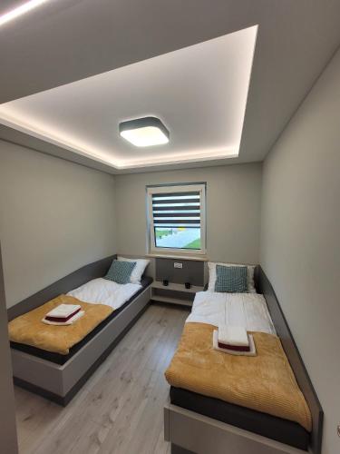 a bedroom with two beds and a tv on the wall at Apartament Jasmin in Zator