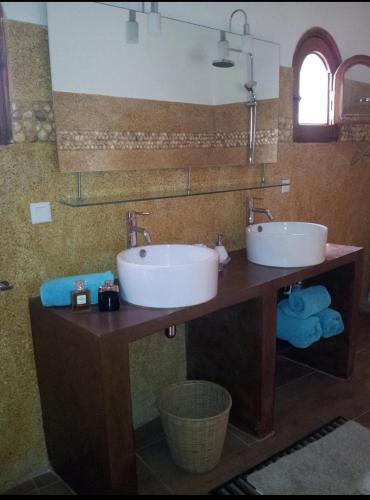 uma casa de banho com 2 lavatórios num balcão de madeira em Warang plage villa em Mbour