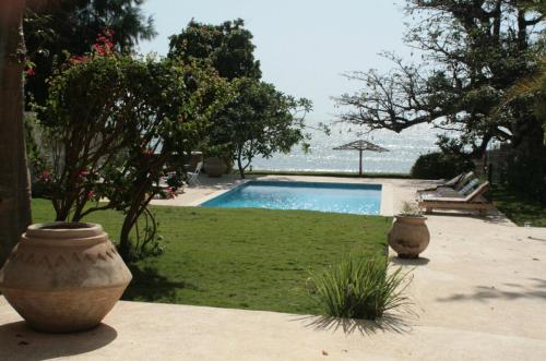 uma piscina com dois vasos grandes num quintal em Warang plage villa em Mbour