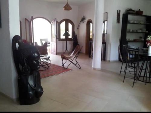 uma sala de estar com cadeiras e uma sala de jantar em Warang plage villa em Mbour