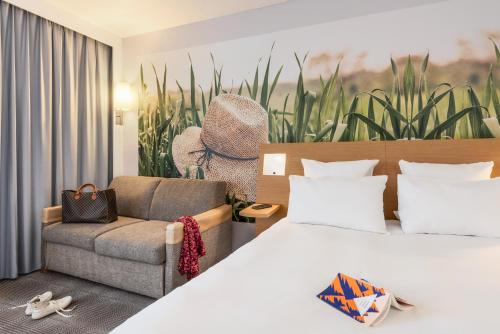 a hotel room with a bed and a chair at Novotel Paris Est in Bagnolet