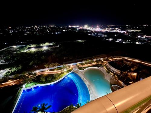 a view of a swimming pool at night at Big Spacious Corner Unit at Azure North wraparound balcony in San Fernando